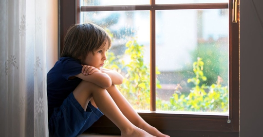 sad child looking out window