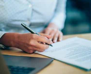 Man signing a document on a table.