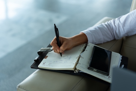 business person making a list on their planner